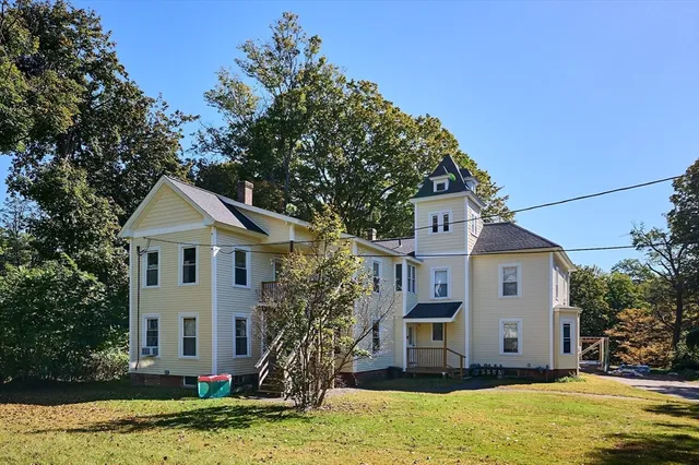 a house view with a garden and large trees
