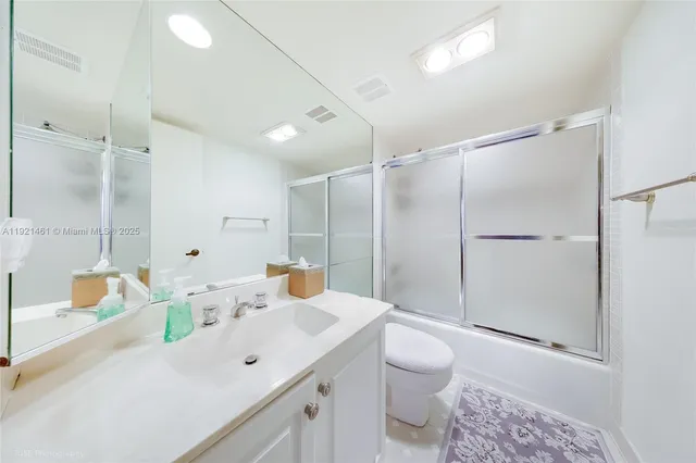 a bathroom with a sink toilet double vanity and shower