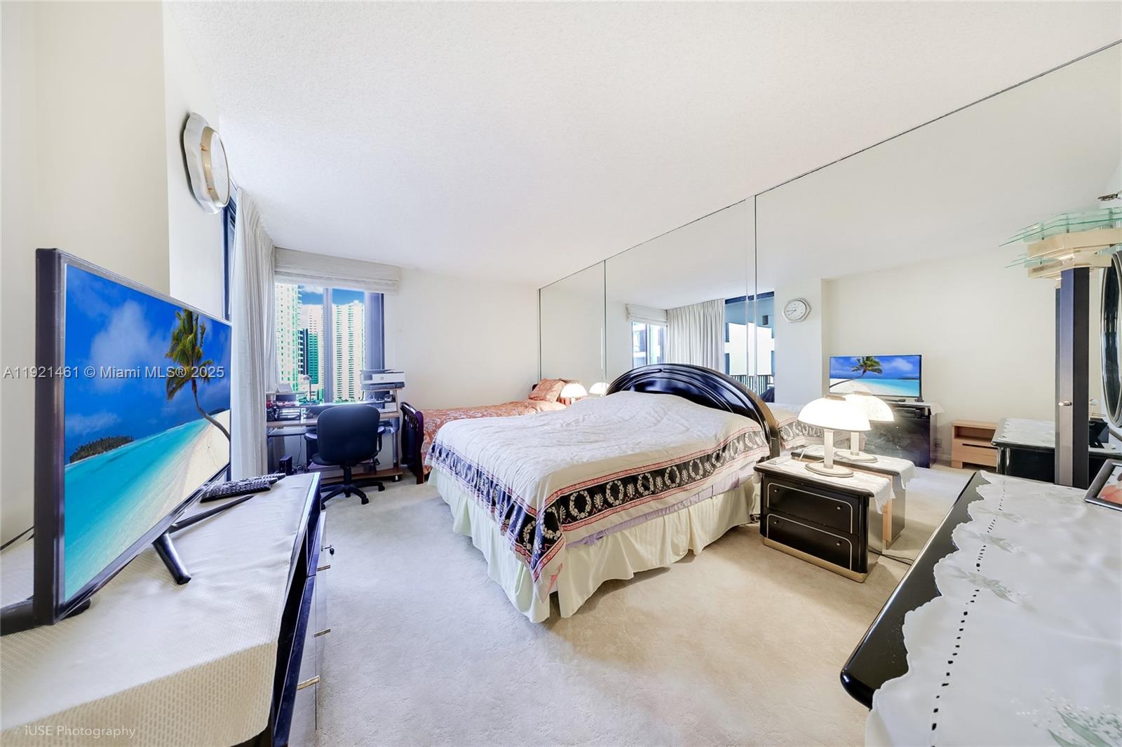 520 Brickell Key Drive, Unit A1510 Miami, FL 33131 - Photo 8 of 15 a spacious bedroom with a bed a couch and a flat screen tv