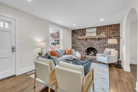a living room with furniture a fireplace and wooden floor
