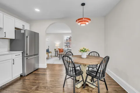 a dining room with furniture a chandelier and wooden floor