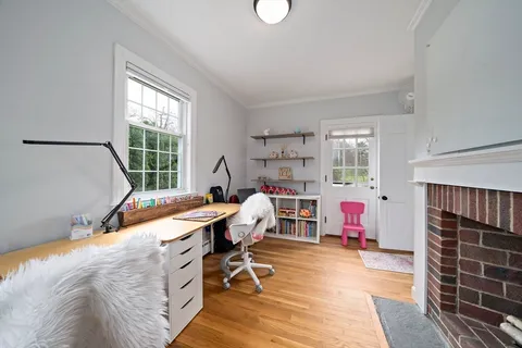 a view of a workspace with furniture and a window