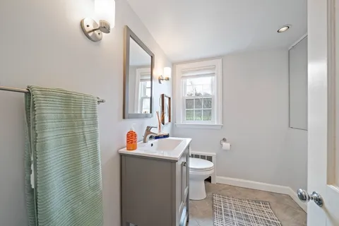 a bathroom with a sink toilet and window