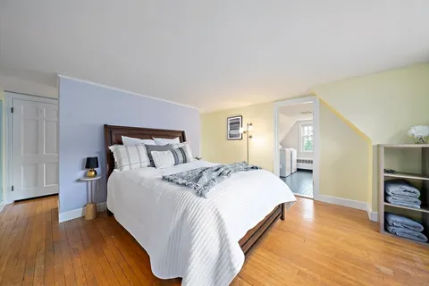 a bedroom with bed and wooden floor