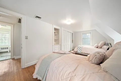 a bedroom with a large bed and wooden floor