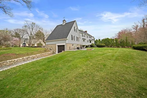 a view of a house with a big yard plants and large trees