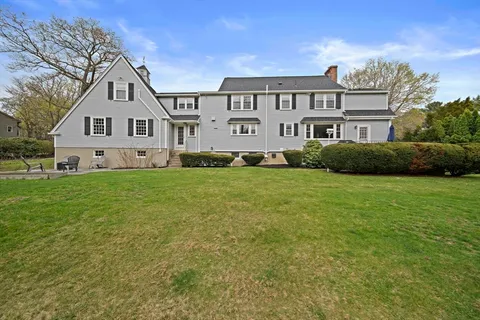 a view of a house with a big yard and large trees