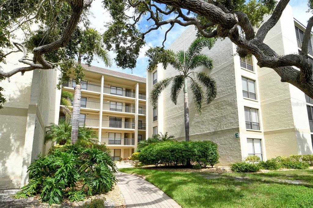 6157 Midnight Pass Road, Unit E63 Sarasota, FL 34242 - Photo 1 of 61 a front view of a house with a yard