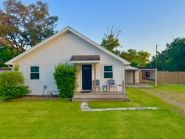 a front view of house with a garden and patio