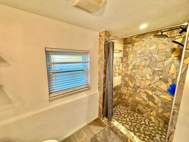 a bathroom with a shower curtain and a window
