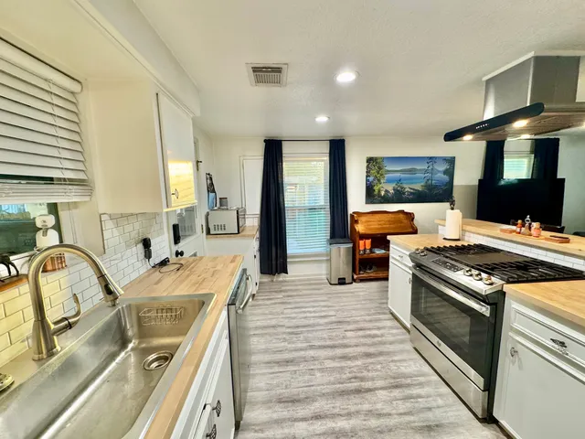 a kitchen with stainless steel appliances granite countertop a sink stove and refrigerator