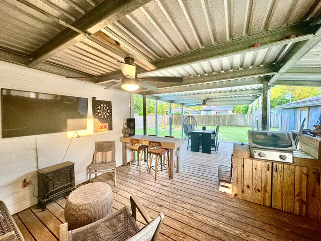 a living room with lots of furniture wooden floor and next to a window