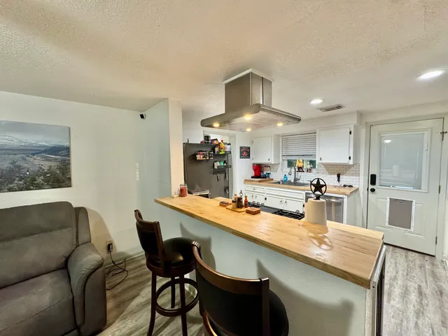 a kitchen with stainless steel appliances a dining table and chairs