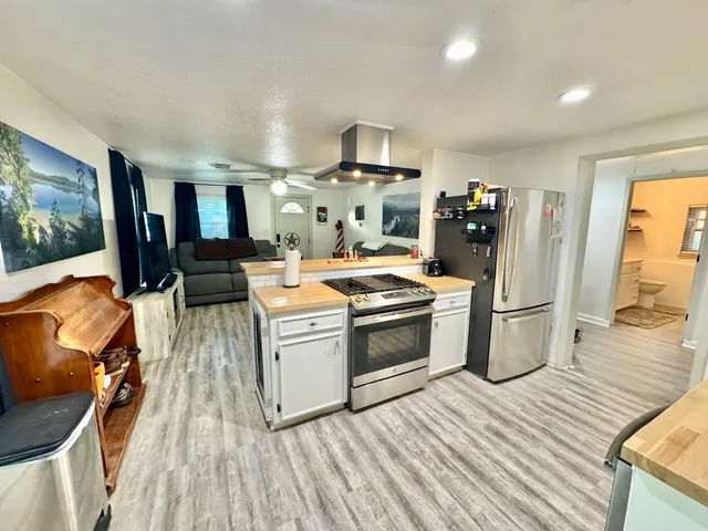 a living room with furniture a flat screen tv and a floor to ceiling window