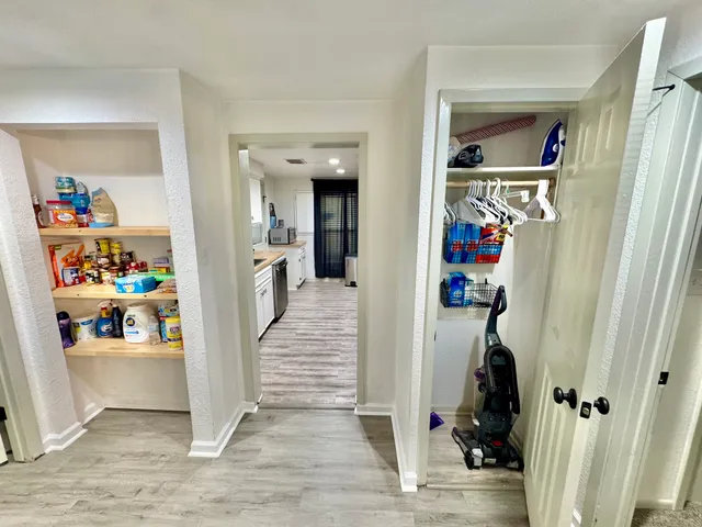 a view of a hallway with wooden floor and closet