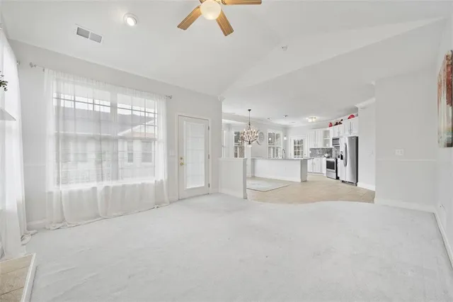 a view of a big room with windows and chandelier fan