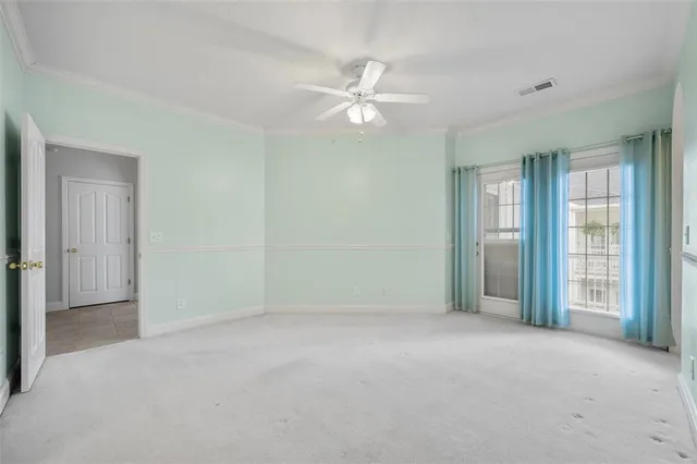 an empty room with closet and a ceiling fan