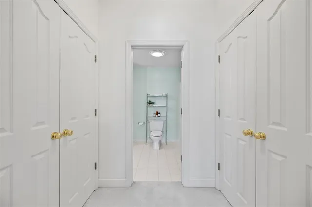 a view of a hallway with white walls and stairs