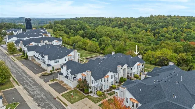 a view of a house with a big yard and large trees