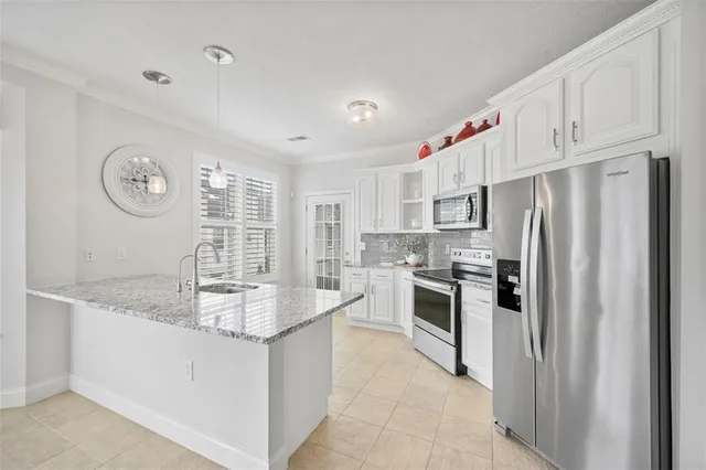 a kitchen with white cabinets and refrigerator