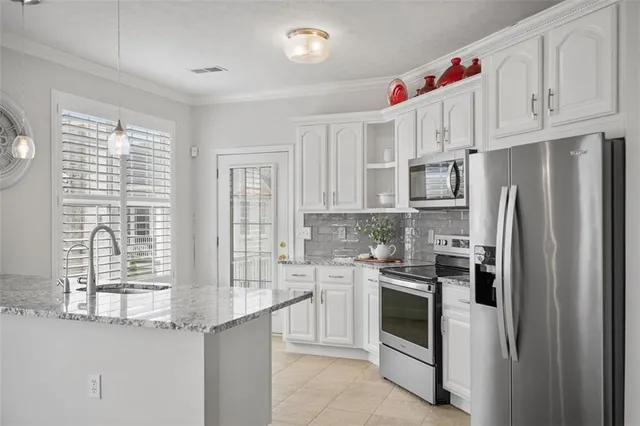 a kitchen with granite countertop a sink stove and cabinets