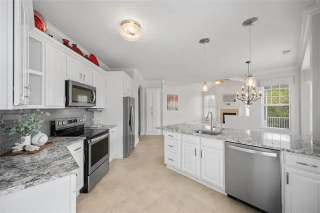 a kitchen with stainless steel appliances granite countertop a refrigerator a stove and a sink