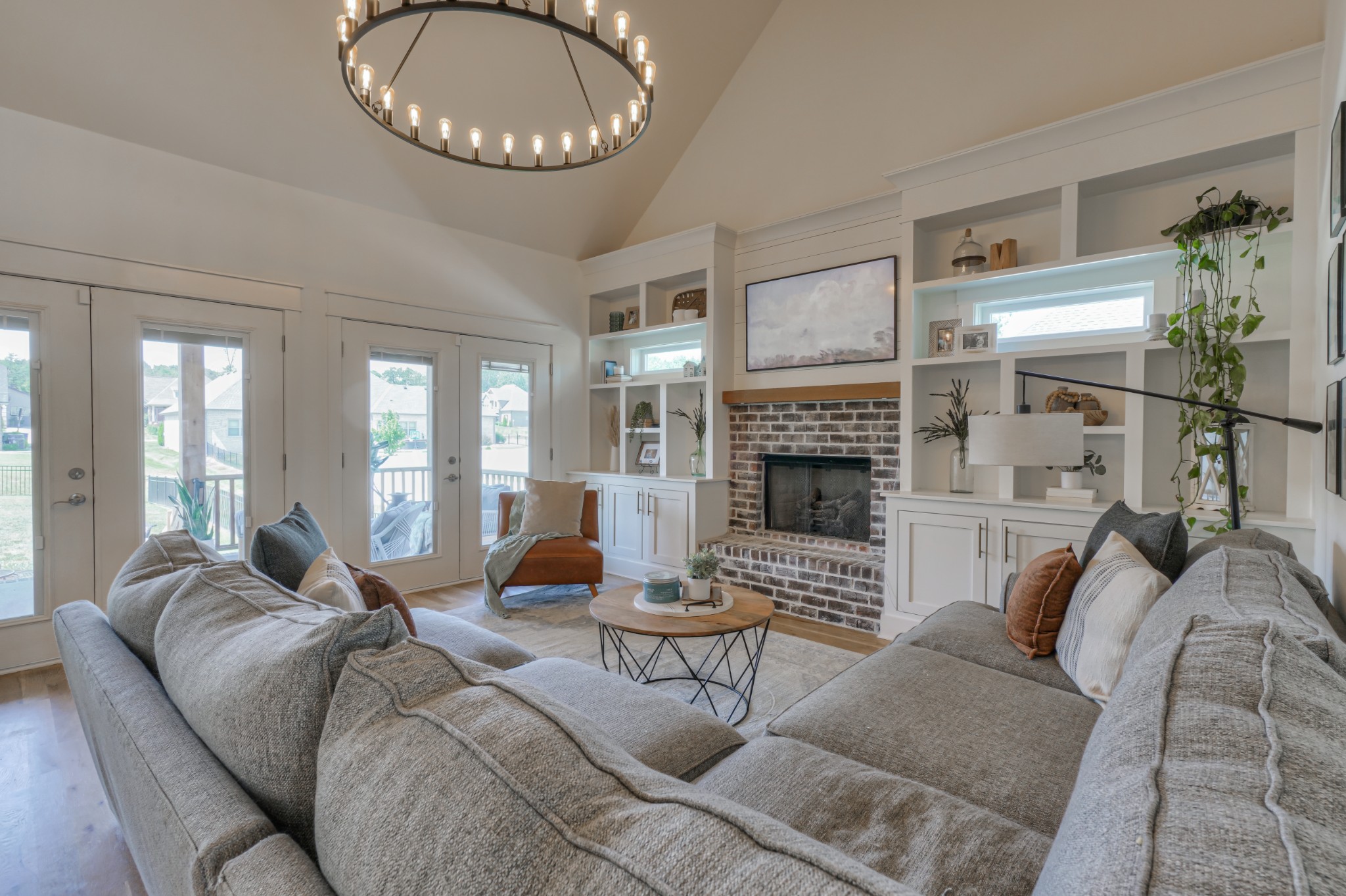 7774 Santos Drive Murfreesboro, TN 37129 - Photo 6 of 42 a living room with furniture a fireplace and a chandelier