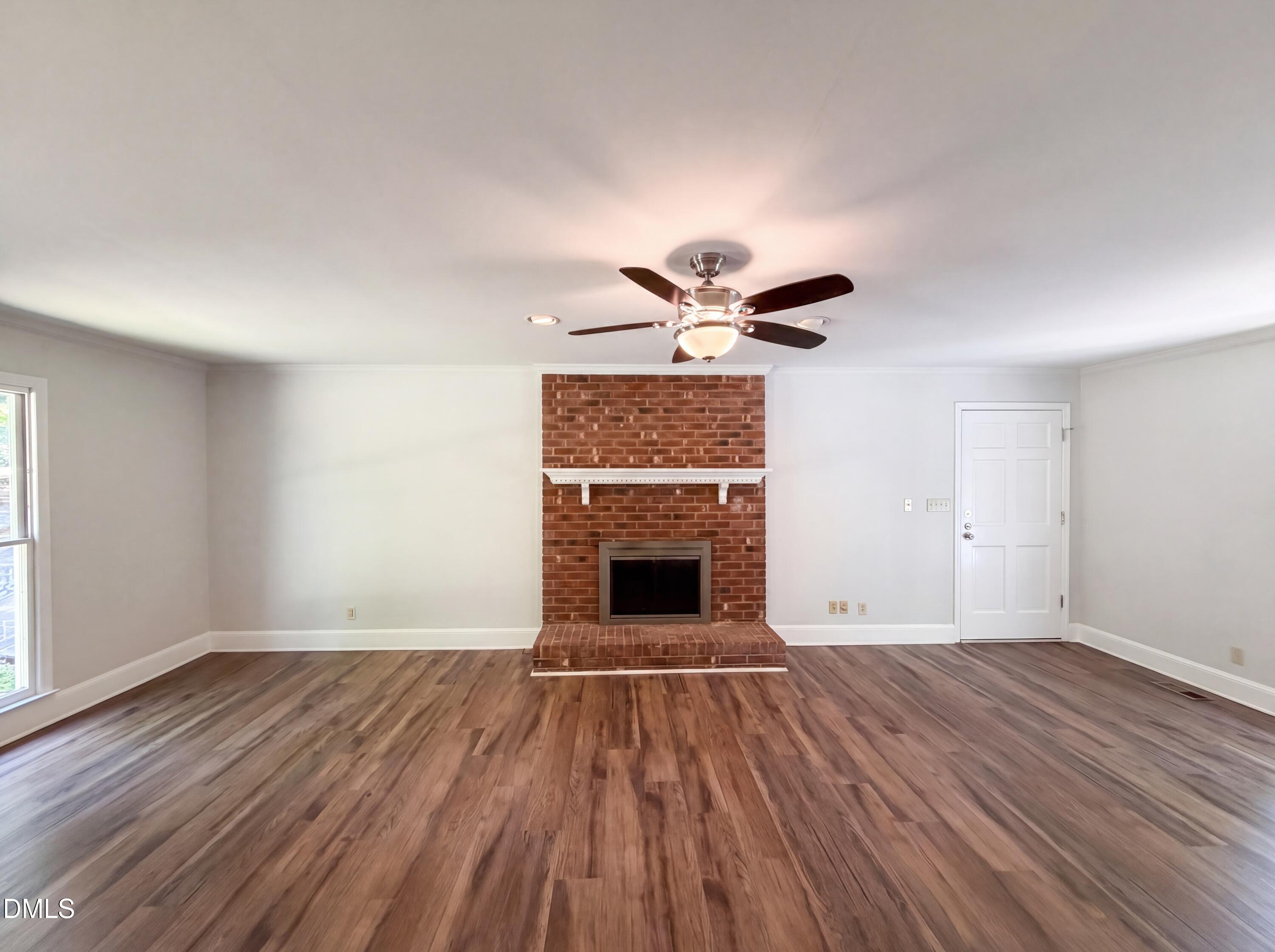 102 Lakeside Farm Road Zebulon, NC 27597 - Photo 3 of 18 a view of empty room with wooden floor and fireplace