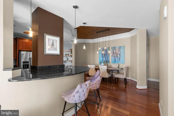 a dining hall with stainless steel appliances granite countertop a kitchen view and chairs