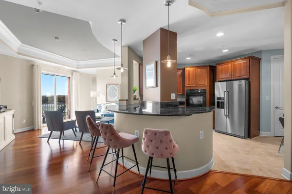 a kitchen with stainless steel appliances granite countertop a refrigerator a stove a sink a oven with a dining table and chairs