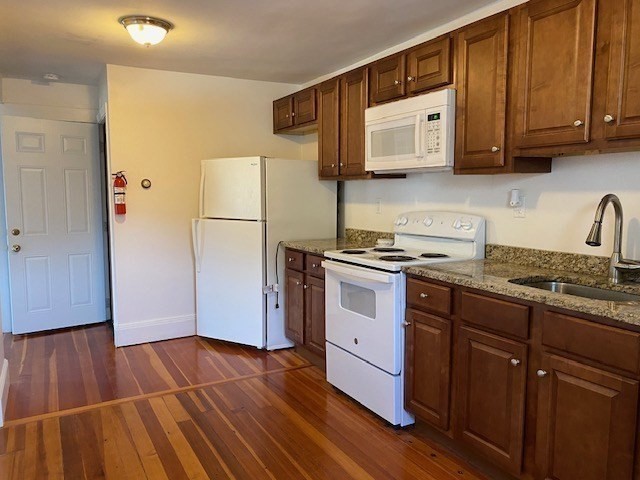 45 Webster Street, Unit 2 Woburn, MA 01801 - Photo 3 of 10 a kitchen with granite countertop wooden floors and white stainless steel appliances