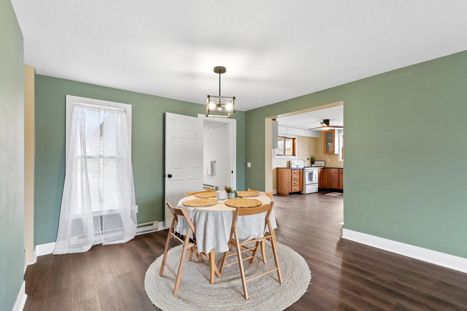 211 Clay Street New Boston, IL 61272 - Photo 8 of 29 a dining room with wooden floor a chandelier a glass table and chairs