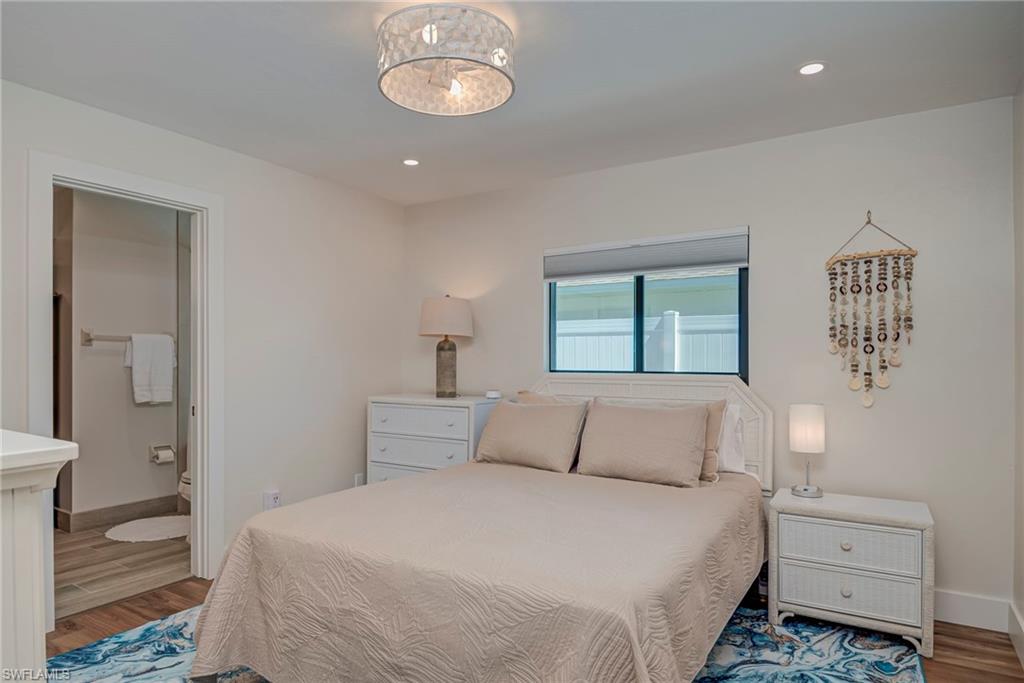 577 98th Avenue North Naples, FL 34108 - Photo 11 of 33 a bedroom with a bed and a lamp
