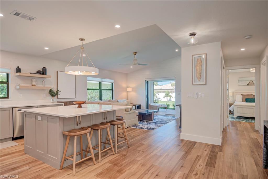 577 98th Avenue North Naples, FL 34108 - Photo 3 of 33 a kitchen with a table chairs refrigerator and cabinets
