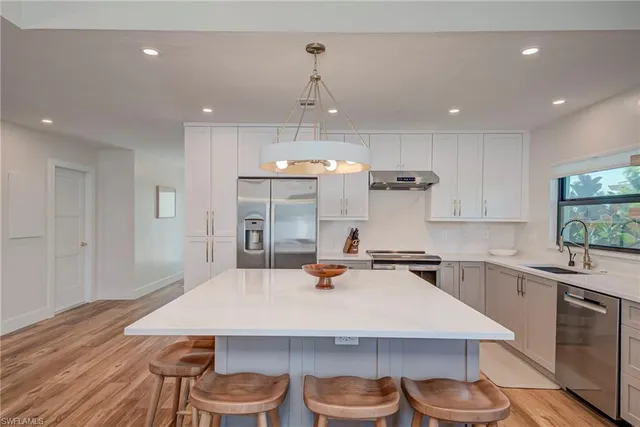 a kitchen with a table chairs sink and cabinets