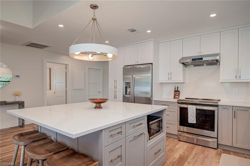 577 98th Avenue North Naples, FL 34108 - Photo 7 of 33 a kitchen with a stove a sink and a refrigerator