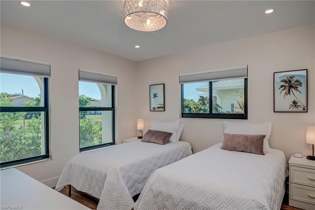 577 98th Avenue North Naples, FL 34108 - Photo 9 of 33 a bedroom with two beds and a large window