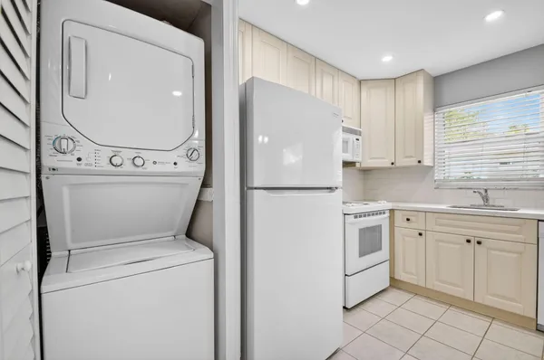 a kitchen with a refrigerator sink and cabinets
