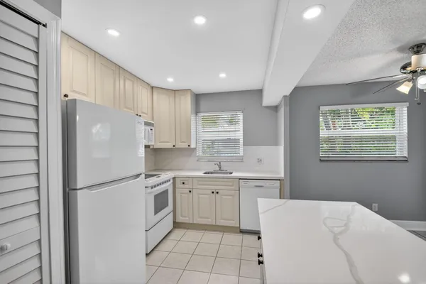 a kitchen with a sink a refrigerator and window