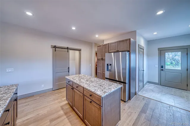 a large kitchen with stainless steel appliances granite countertop a large counter top and wooden floors