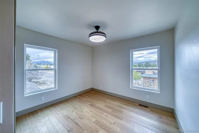an empty room with wooden floor cabinet and closet
