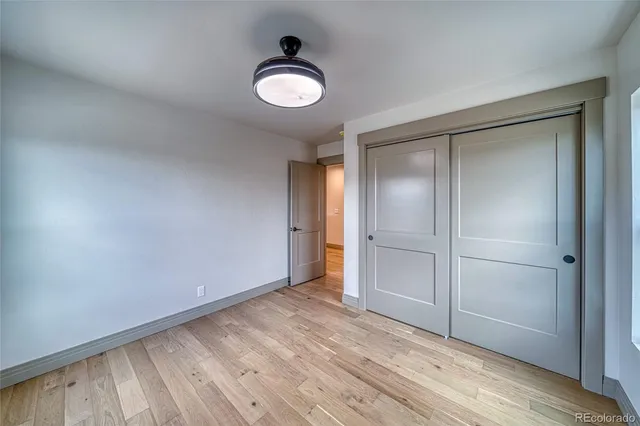 a bathroom with a granite countertop sink a toilet a mirror and shower