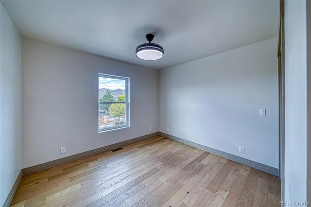 a view of empty room with wooden floor