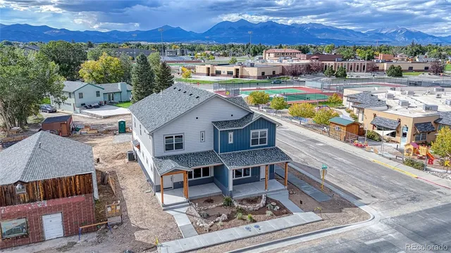 a aerial view of a house with swimming pool and large trees