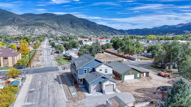 an aerial view of a house with a mountain