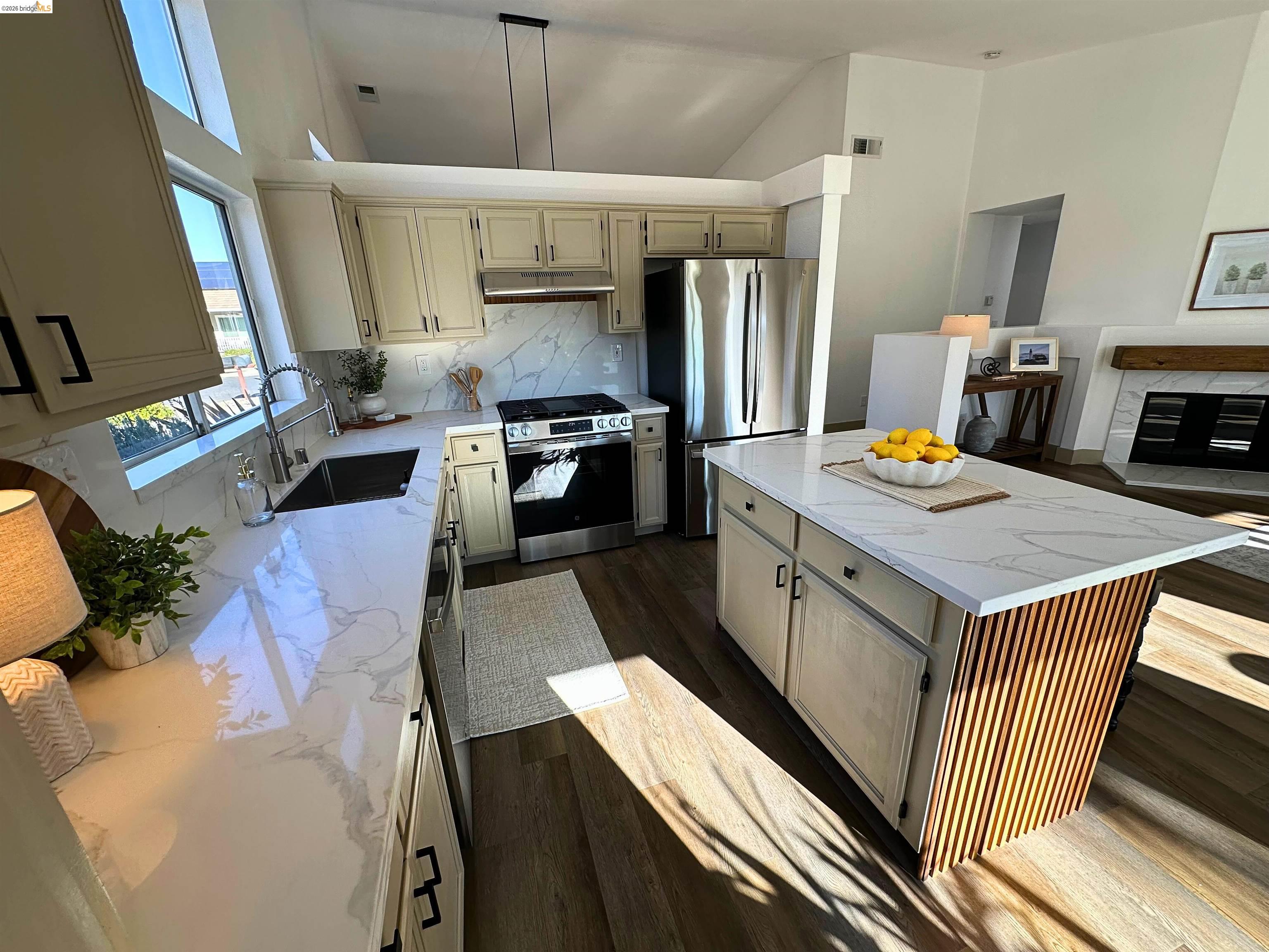 3075 Shiles Loop Brentwood, CA 94513 - Photo 18 of 37 Kitchen featuring a kitchen island, light stone counters, stainless steel appliances, tasteful backsplash, and dark wood-style floors