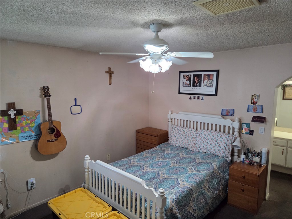 44047 Rodin Avenue Lancaster, CA 93535 - Photo 5 of 26 a bedroom with a bed and a chandelier