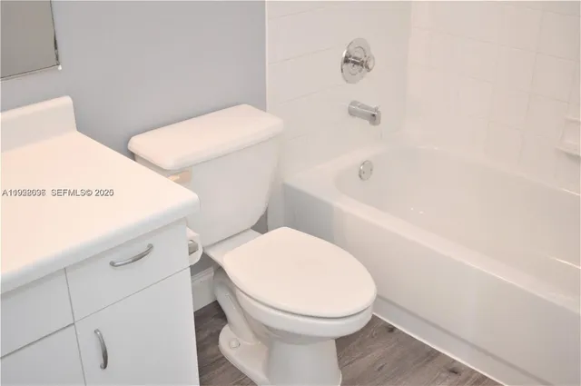 a white toilet sitting next to a bath tub