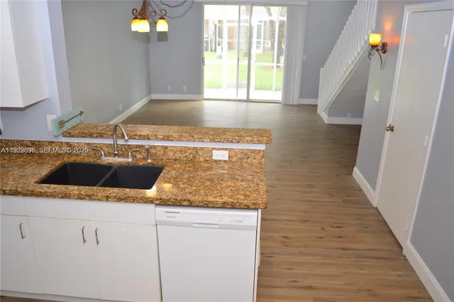 a kitchen with a sink a stove and cabinets