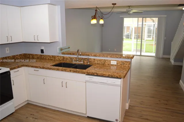 a kitchen with granite countertop a sink and a stove